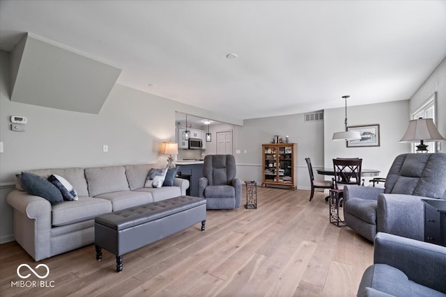 living area featuring visible vents and light wood-style flooring