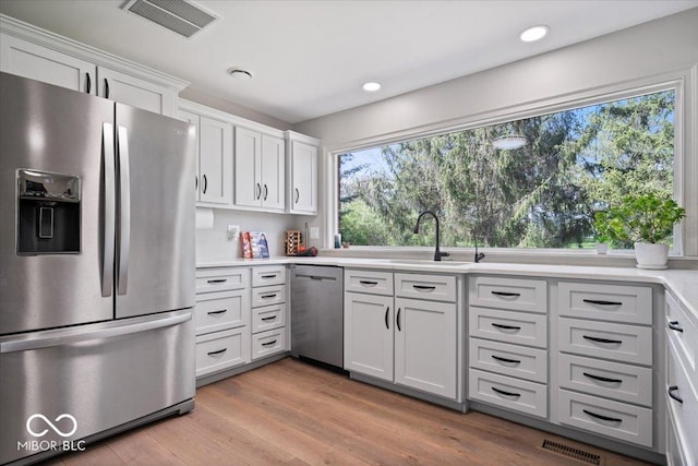 kitchen featuring light countertops, appliances with stainless steel finishes, a sink, and visible vents