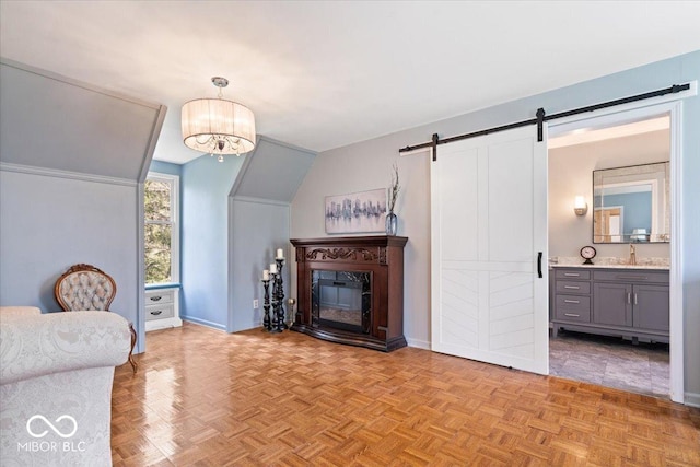 living room with baseboards, a barn door, and a chandelier