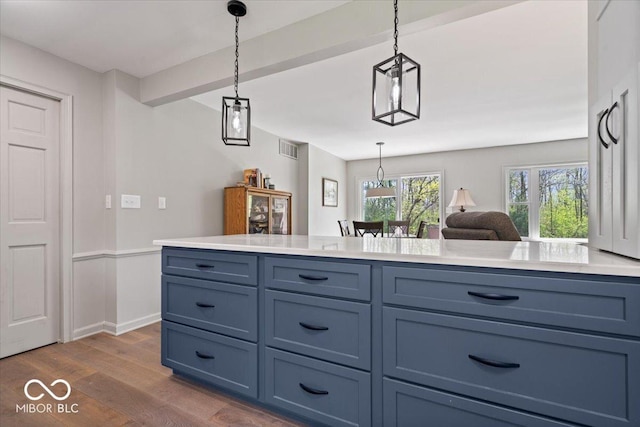 kitchen with visible vents, hanging light fixtures, dark wood finished floors, light countertops, and baseboards