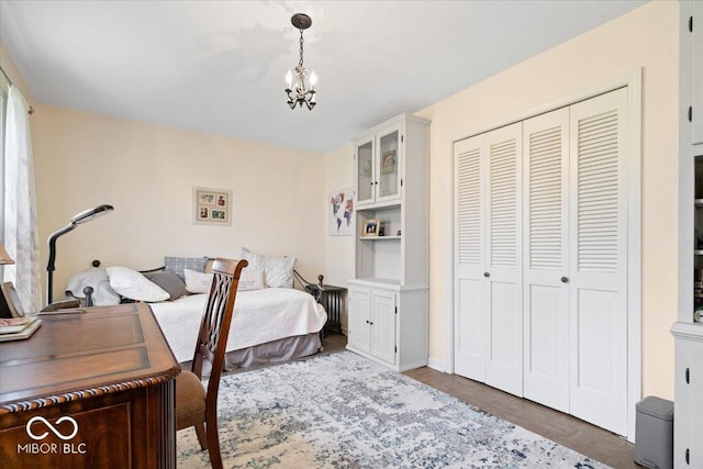 bedroom with a closet, wood finished floors, and a notable chandelier