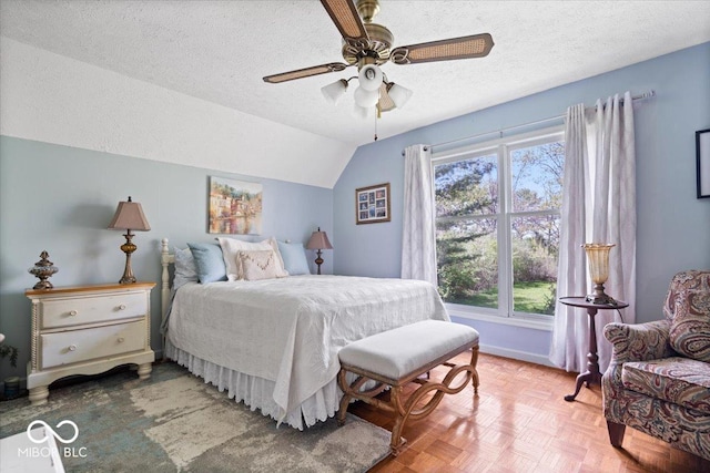 bedroom featuring baseboards, a ceiling fan, vaulted ceiling, and a textured ceiling