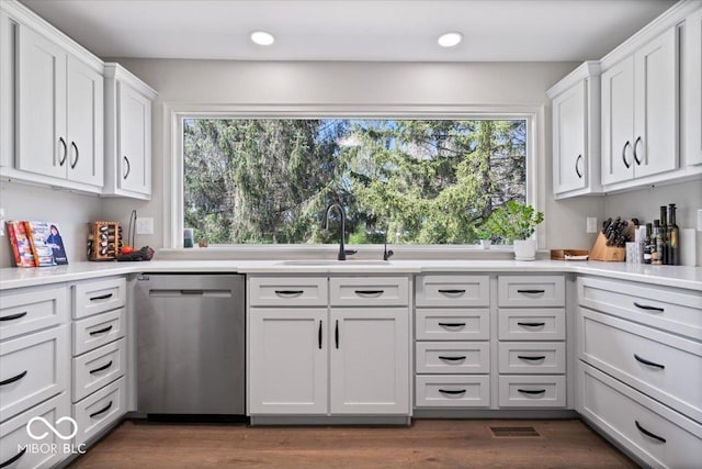 kitchen featuring stainless steel dishwasher, white cabinetry, recessed lighting, and a sink