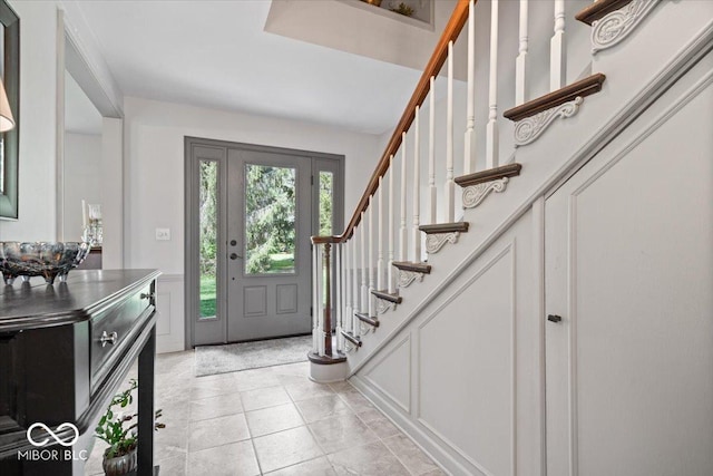 foyer entrance featuring stairs and a decorative wall
