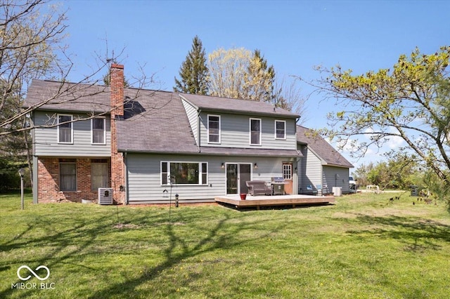 back of house with central air condition unit, brick siding, a deck, a chimney, and a lawn
