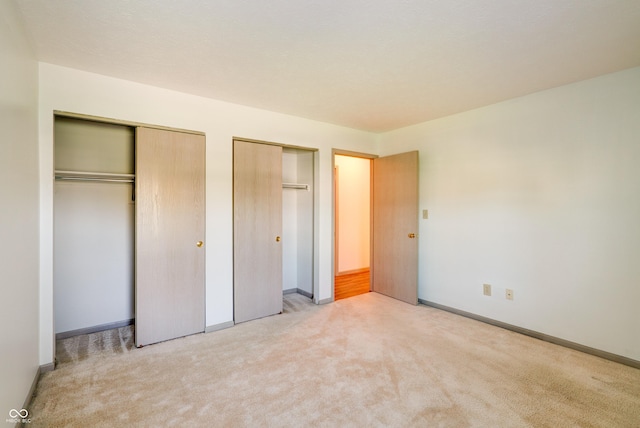 5839 Quail Run Dr, Indianapolis, IN 46237 - unfurnished bedroom featuring baseboards, multiple closets, and light carpet