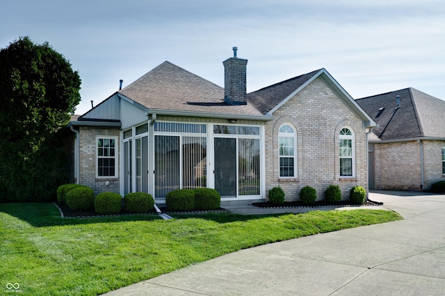 5839 Quail Run Dr, Indianapolis, IN 46237 - view of front facade with driveway, a chimney, a sunroom, brick siding, and a front lawn
