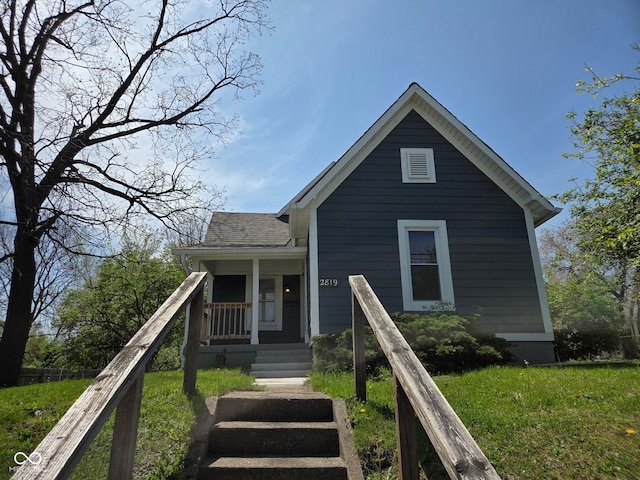 2819 W 16th St, Indianapolis, IN 46222 - view of front of property with a porch, a shingled roof, and a front lawn