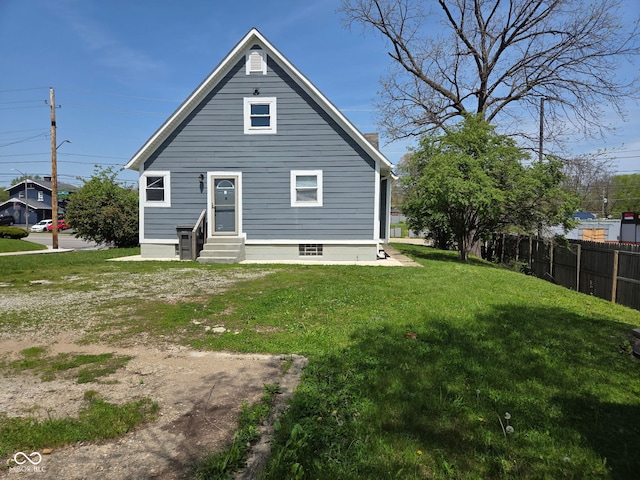 2819 W 16th St, Indianapolis, IN 46222 - back of house with entry steps, fence, a chimney, and a lawn