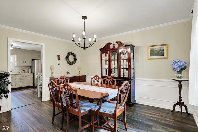 12669 Brookshire Pkwy, Carmel, IN 46033 - dining area featuring crown molding, a wainscoted wall, an inviting chandelier, and dark wood-style flooring