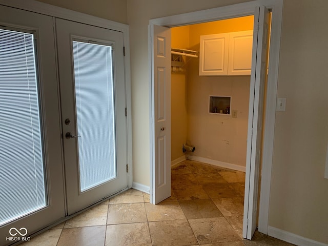 laundry room featuring french doors, cabinet space, hookup for a washing machine, a heating unit, and baseboards