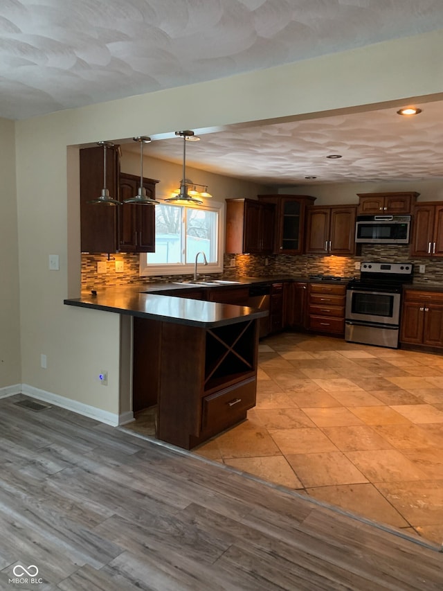 kitchen featuring decorative backsplash, dark countertops, and appliances with stainless steel finishes