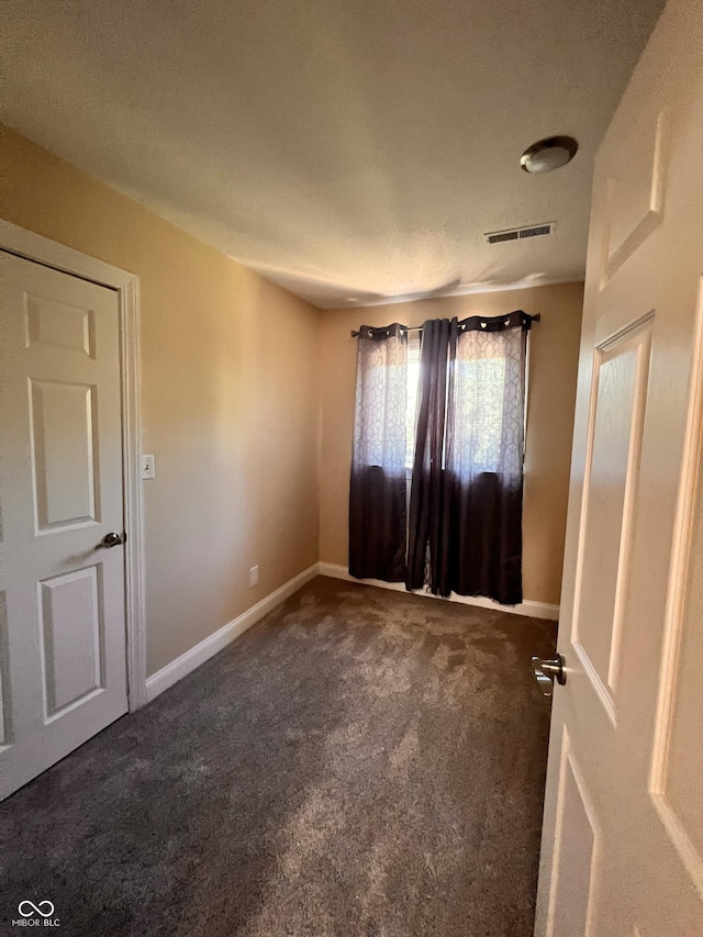 unfurnished room featuring carpet floors, baseboards, and visible vents