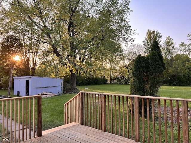 wooden terrace featuring a yard and an outdoor structure