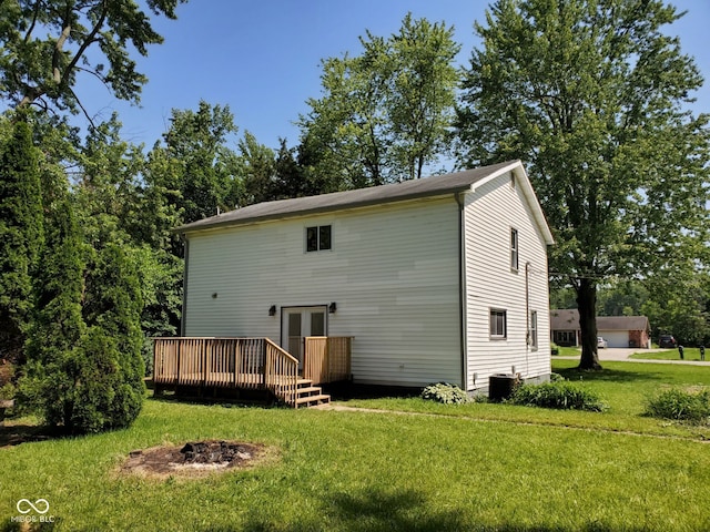 back of property featuring a lawn, a deck, french doors, and a fire pit