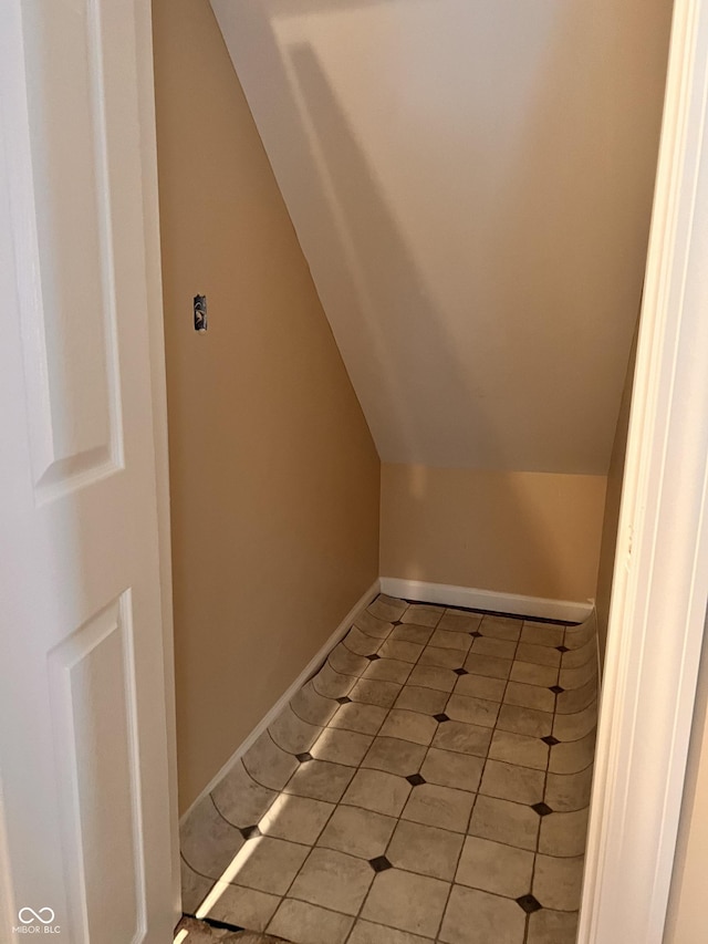 bonus room with light tile patterned floors, baseboards, and vaulted ceiling