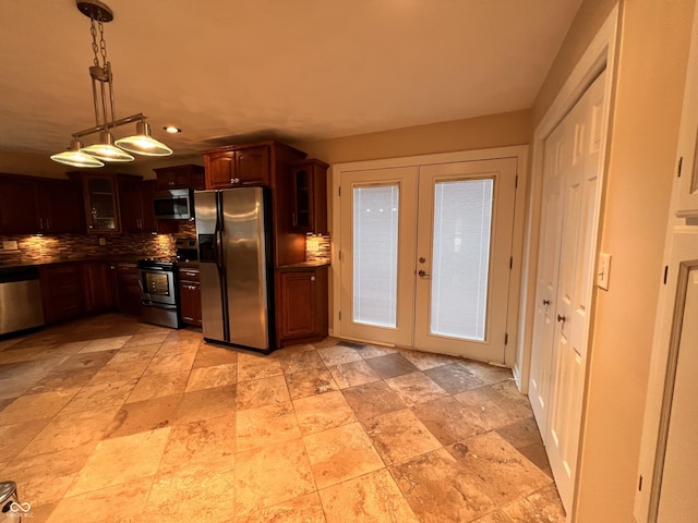 kitchen with appliances with stainless steel finishes, glass insert cabinets, french doors, and backsplash