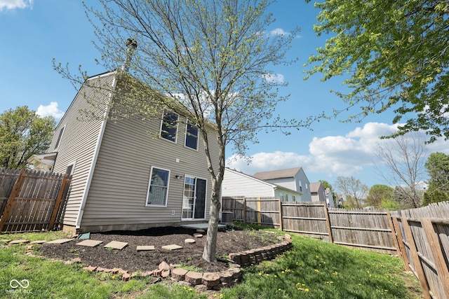 rear view of property featuring a fenced backyard and central AC unit
