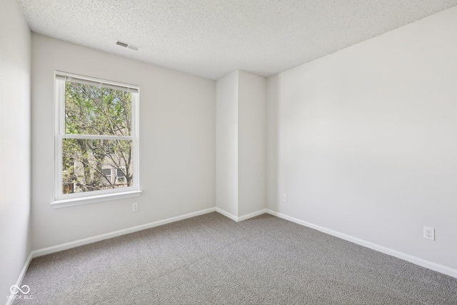 unfurnished room featuring carpet flooring, a textured ceiling, visible vents, and baseboards