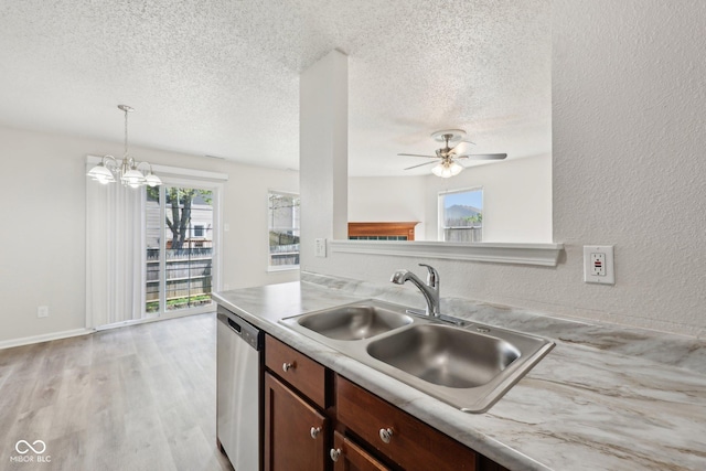 kitchen with a textured ceiling, stainless steel dishwasher, a sink, light countertops, and ceiling fan with notable chandelier