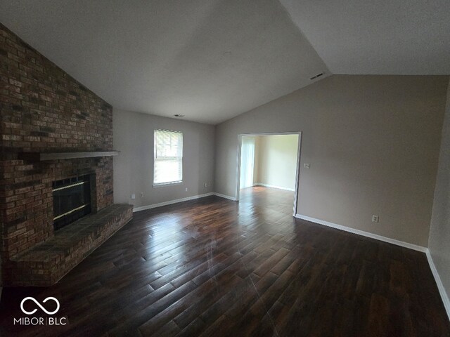 9118 Lansburgh Ct, Indianapolis, IN 46234 - unfurnished living room featuring dark wood-type flooring, lofted ceiling, a fireplace, and baseboards