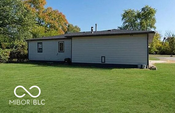 back of property with a lawn