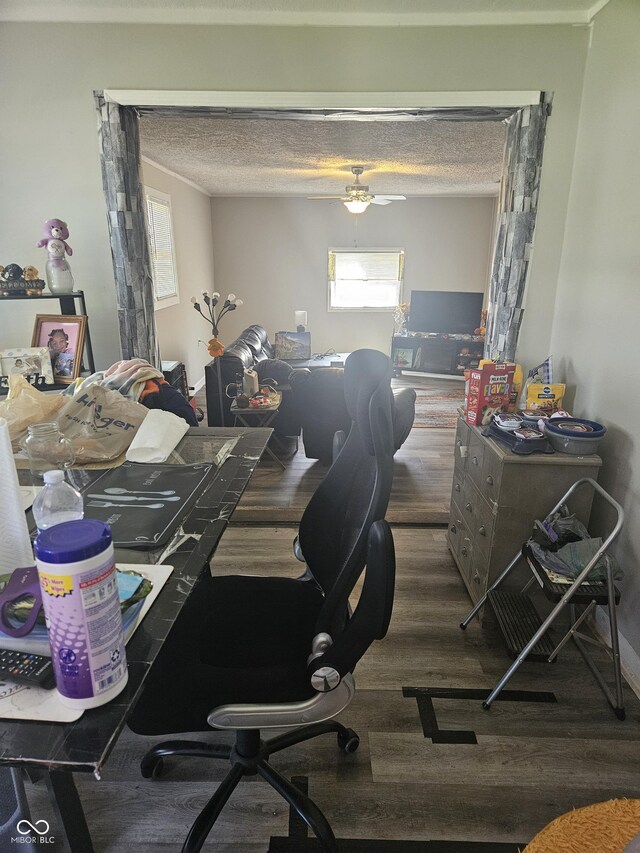 dining room with wood finished floors, a desk, a ceiling fan, a textured ceiling, and crown molding