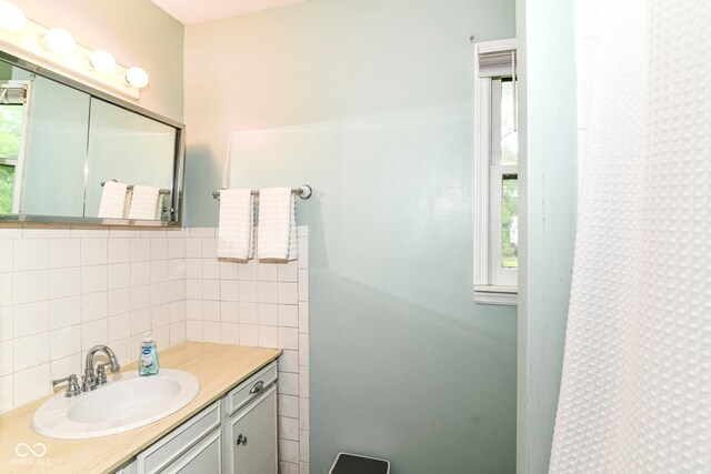 7140 Avalon Trail Dr, Indianapolis, IN 46250 - bathroom featuring decorative backsplash, vanity, and tile walls