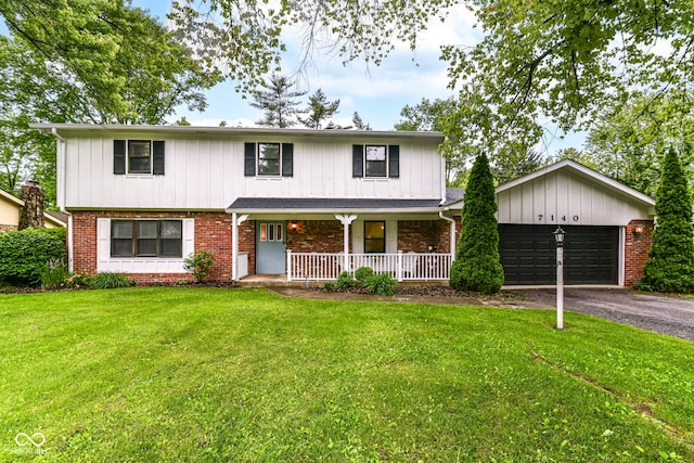 7140 Avalon Trail Dr, Indianapolis, IN 46250 - traditional-style house with driveway, a porch, an attached garage, a front yard, and brick siding