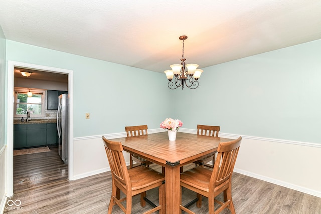 7140 Avalon Trail Dr, Indianapolis, IN 46250 - dining space with light wood-style flooring, a chandelier, and baseboards