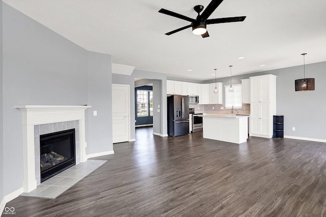 6827 Fallen Leaf Dr, Whitestown, IN 46075 - unfurnished living room with ceiling fan, dark wood finished floors, a tiled fireplace, and recessed lighting