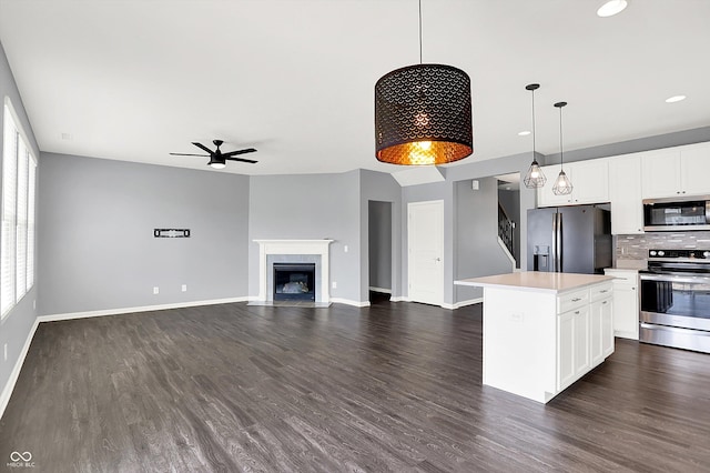 6827 Fallen Leaf Dr, Whitestown, IN 46075 - kitchen with stainless steel appliances, ceiling fan, light countertops, a kitchen island, and tasteful backsplash