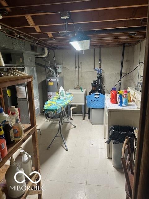 unfinished below grade area featuring water heater, independent washer and dryer, and a sink