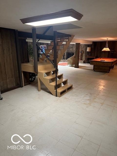 basement with wood walls, stairs, and pool table