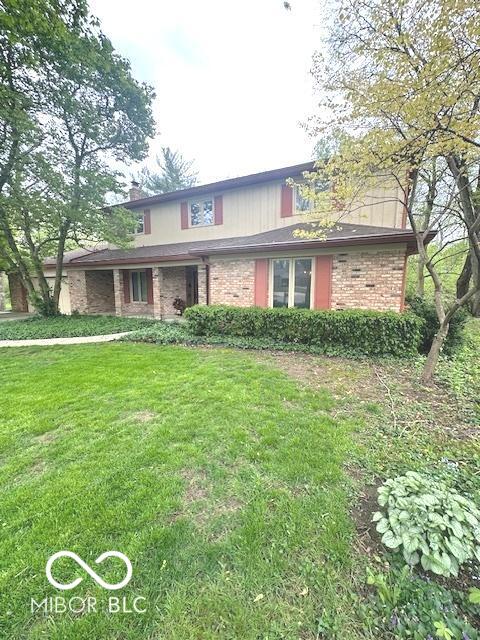 traditional-style house with brick siding and a front yard
