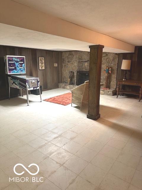 interior space featuring light floors, wooden walls, and a fireplace