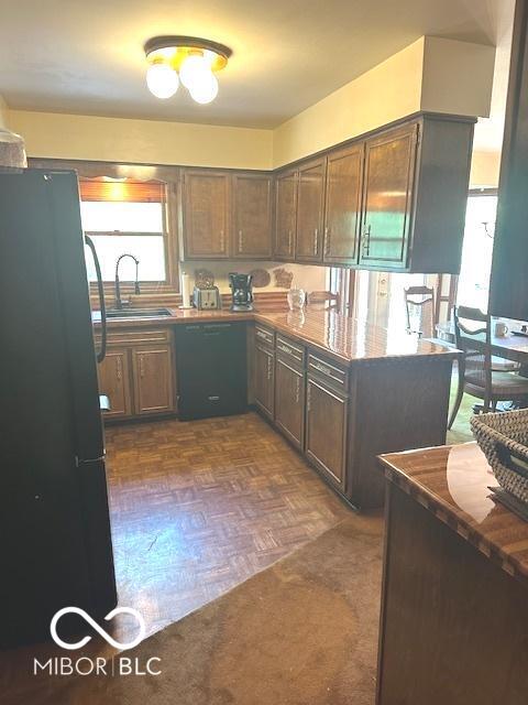 kitchen featuring a sink, black appliances, and dark countertops