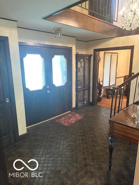 foyer entrance with an inviting chandelier, baseboards, and stairs