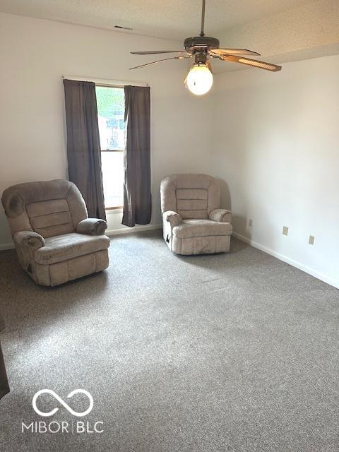 living area featuring carpet flooring, baseboards, and ceiling fan
