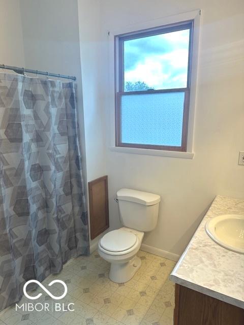 full bath with vanity, toilet, a shower with curtain, and baseboards