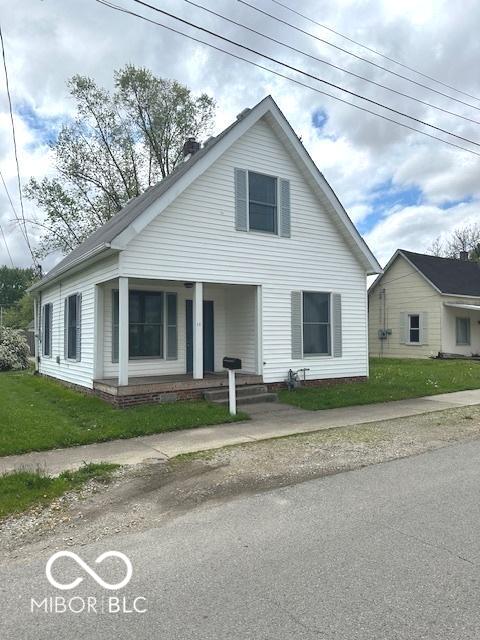 bungalow-style home with a front lawn and covered porch