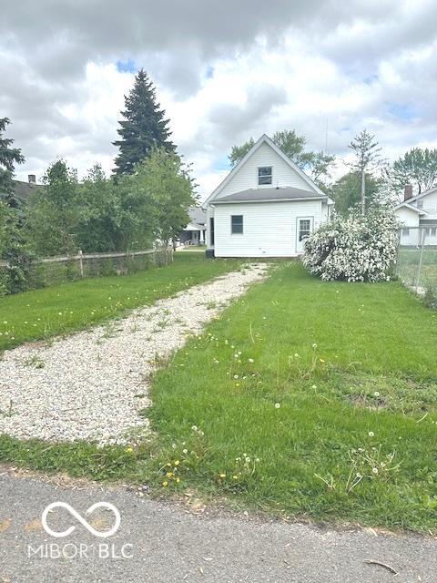 view of property exterior featuring fence and a lawn