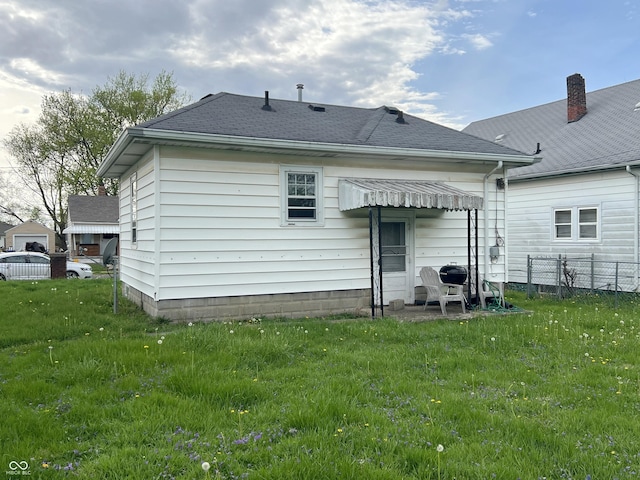 3434 Forrest Ter, Anderson Se, IN 46013 - back of house with roof with shingles, a yard, and fence