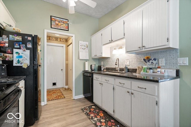 kitchen with backsplash, a sink, white cabinets, black appliances, and light wood-style flooring
