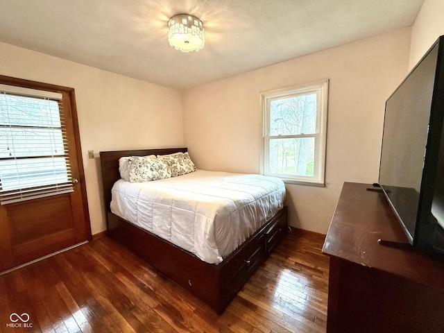 bedroom with baseboards and dark wood-type flooring