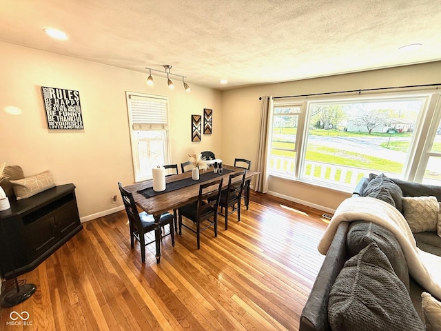 dining area featuring a textured ceiling, baseboards, recessed lighting, and hardwood / wood-style floors