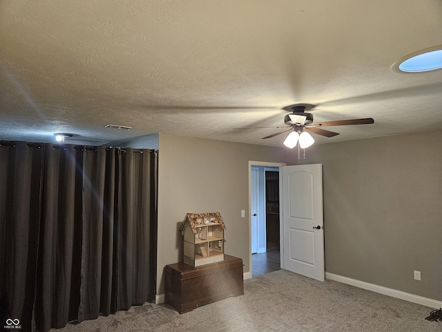 living area featuring carpet floors, baseboards, visible vents, and ceiling fan