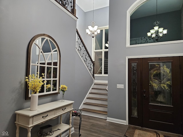 entryway with stairs, baseboards, a high ceiling, dark wood-type flooring, and a chandelier
