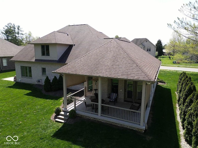 back of property featuring a lawn and brick siding