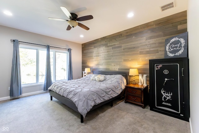 bedroom with carpet floors, visible vents, baseboards, wooden walls, and recessed lighting